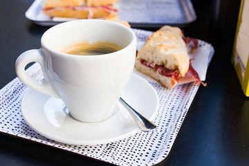 Breakfast in spanish cafe. Coffee Americano in white cup and toast with jamon iberico. Barcelona