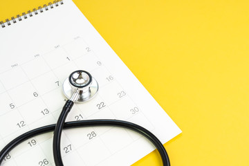 Stethoscope on clean calendar with copy space to put month and year, reminder for annual health checkup, medical appointment or examination schedule or remind to meet the doctor concept