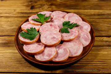 Ham sausage on a plate on wooden table