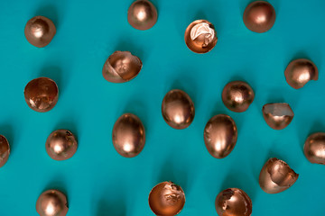 top view golden easter eggs and egg shells on a blue background