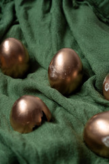 golden eggs on a green textile selective focus blurred background