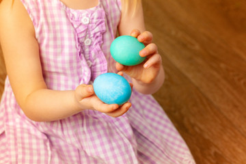 Fototapeta na wymiar Little girl's hand holding painted Easter egg. Close up shot