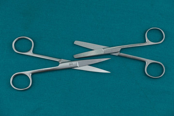 Basic surgical instrument stainless steel operation scissors curve s/s and Straight b/b isolated on surgical green drape fabric