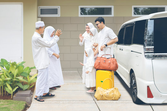 Young Muslim Family With Daughter Waving Hands Saying Goodbye To Parents After Celebrating Eid Mubarak