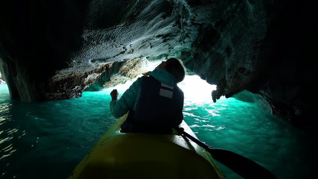 Woman explores limestone rock formation and swims inside the cave (Marble Caves) on the lake General Carrera in Chilean Patagonia, Aysen region, Chile