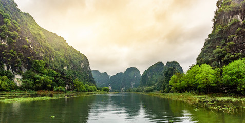 Tam Coc National Park - Tourists traveling in boats along the Ngo Dong River at Ninh Binh Province,...