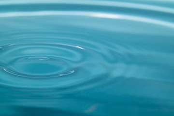 Obraz premium Closeup Water drop falling on the surface of the water and beautiful circular wave ripple, fresh natural mineral water drink water concept