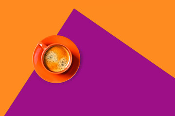 Orange and purple background with cup of tasty coffee. Flat lay, top view, copy space. Geometric composition.