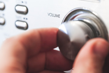 Hand on a volume control knob, close up-photo