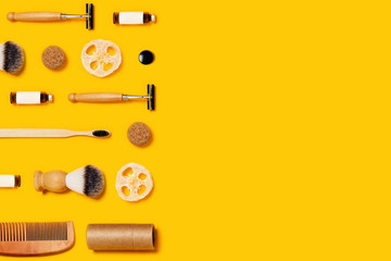 Ecological accessories for body care located on yellow background. Flat lay, top view, copy space.