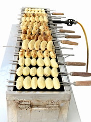 Banana grilled on a grill isolated on white background.cultivated banana fruit on a hot charcoal grill in Thailand outdoor market,It's a traditional Thai cuisine food gourmet