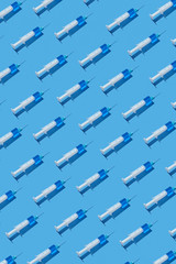 Medical pattern of disposable syringes with blue injectable liquid.