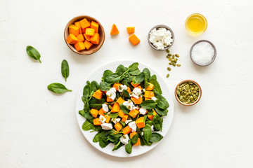 Fototapeta na wymiar Cooking salad with pumpkin and basil. Ingredients on white background top-down