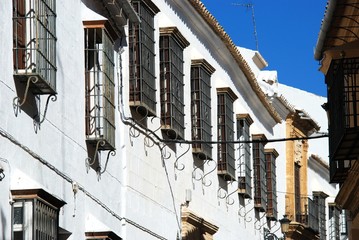 Fototapeta na wymiar Traditional townhouses with ornate wrought iron window grills, Osuna, Spain.