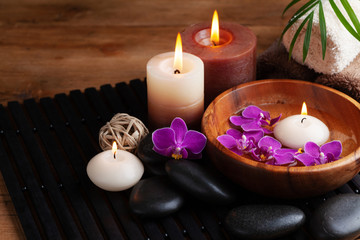 Obraz na płótnie Canvas Spa, beauty treatment and wellness background with massage stone, orchid flowers, towels and burning candles.