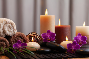 Obraz na płótnie Canvas Aromatherapy, spa, beauty treatment and wellness background with massage stone, orchid flowers, towels and burning candles...