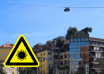 Corona virus concept with warning sign and apartment buildings in Milan (Italy) in background...