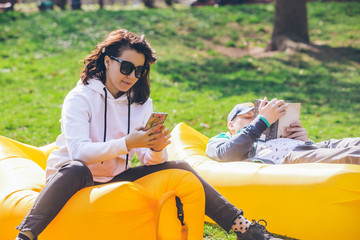 couple laying in city park on yellow inflatable mattress