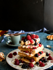 waffeln gestapelt, mit frischkäse gefüllt und verschiedenen beeren belegt