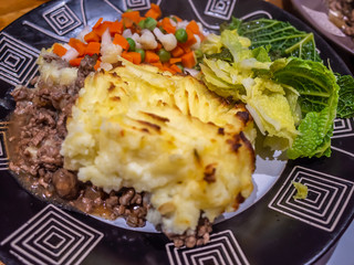 Cottage pie, mixed veg and fresh green cabbage on a plate