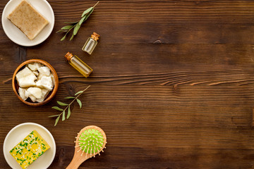 Hair care concept. Coconut oil, brush on dark wooden background top-down frame copy space