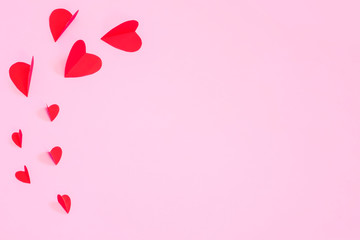 Love Valentine's day concept. Red hearts on a pink pastel background to copy space.