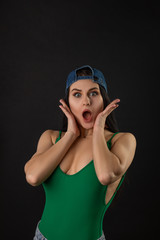 Fashion photo of beautiful brunette caucasian woman with long hair, sexy woman wearing green swimsuit jeans and cap.