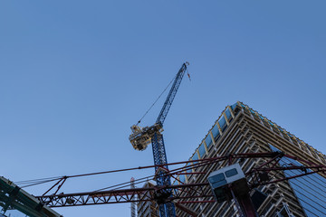 Fototapeta na wymiar Construction of a skyscraper on blue sky background