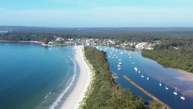 Aerial drone view of Huskisson on the New South Wales South Coast, Australia, showing Currambene Creek and Jervis Bay on a bright sunny day   