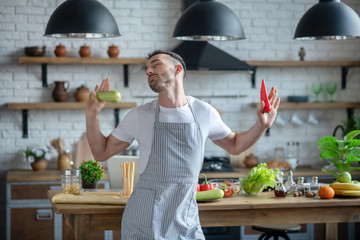 Man in an apron standing with his eyes closed.