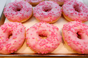 Background of pink donuts on a tray