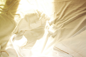 White crumpled bed in the sunlight. Home Textiles. Flat Lay Style