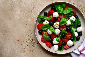 Caprese - traditional italian salad with tomatoes, basil and mozzarella. Top view with copy space.
