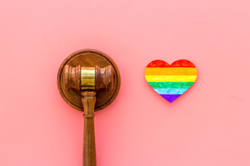 LGBT divorce. Rainbow heart near judge gavel on pink background top-down