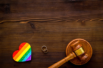 LGBT divorce. Rainbow heart near judge gavel on wooden background top-down copy space