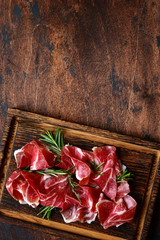Slices of prosciutto di parma or jamon serrano (iberico) . Top view with copy space.