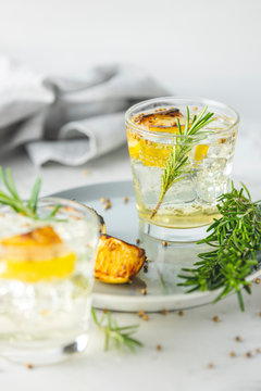 Glasses of Gin and Tonic with Charred Lemon, Rosemary and Coriander is a flavors are perfectly balanced refreshing cocktail. on light background, close up surrounded ingredients, selective focus