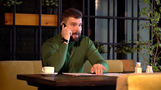 Modern guy calling by smartphone in a caffe