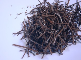 photo of hundreds of rusty nails on white background.