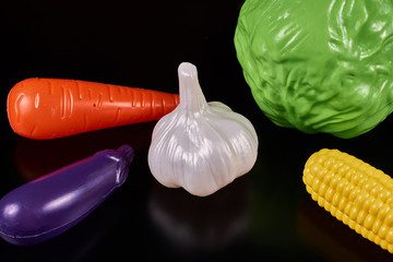 Plastic vegetables isolated on a dark background