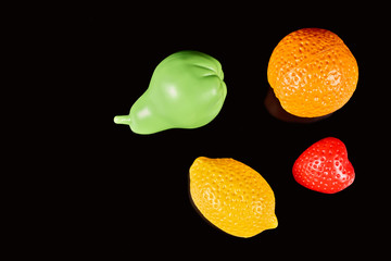 Plastic fruits isolated on a dark background