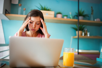 Portrait young stressed displeased worried business woman sitting in front of laptop