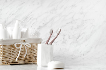 Basket with body care accessories on marble background.