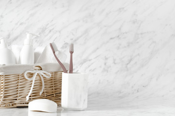 Basket with body care accessories on marble background.