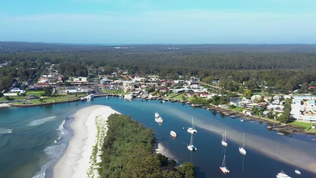Aerial drone view of Huskisson on the New South Wales South Coast, Australia, showing Currambene Creek and Jervis Bay on a bright sunny day   