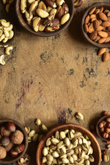 Variety of nuts in a wooden bowl. Top view with copy space.