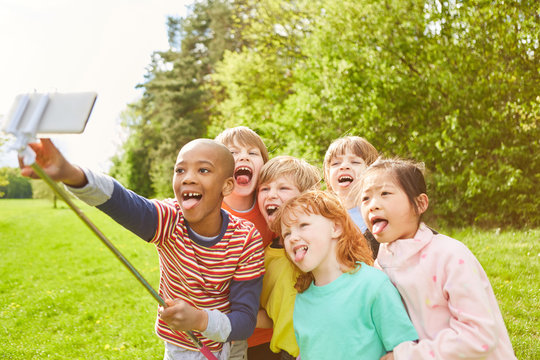 Gruppe Kinder macht ein Selfie und zeigt die Zunge