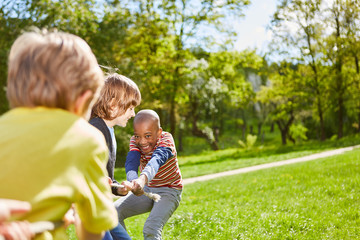 Kinder im Park beim Wettkampf im Tauziehen