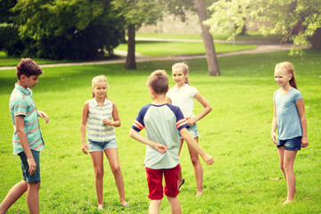 Obraz premium friendship, childhood, leisure and people concept - group of happy kids or friends playing game in summer park