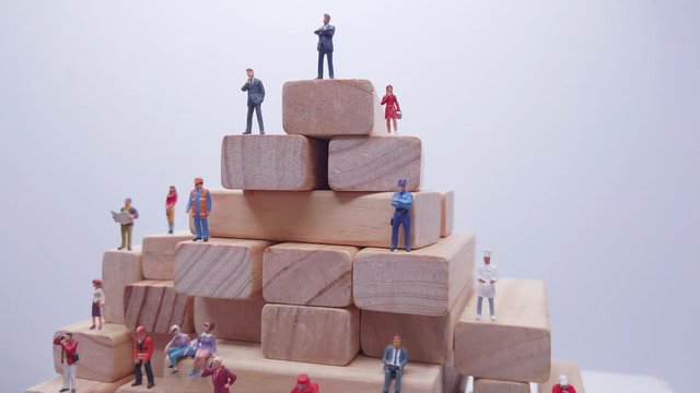 Studio shots miniature figure toys - recruitment or jobs available concept. Various types of jobs for employment on rotating wooden blocks platform.